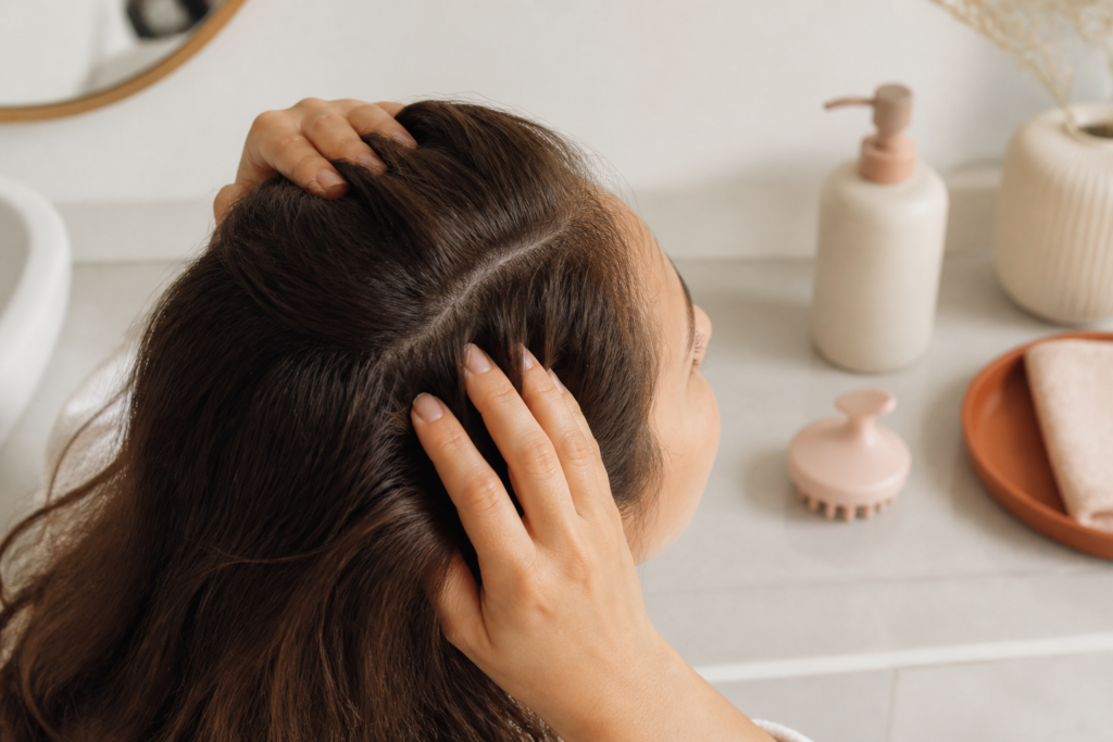Pessoa separando delicadamente o cabelo para observar o couro cabeludo